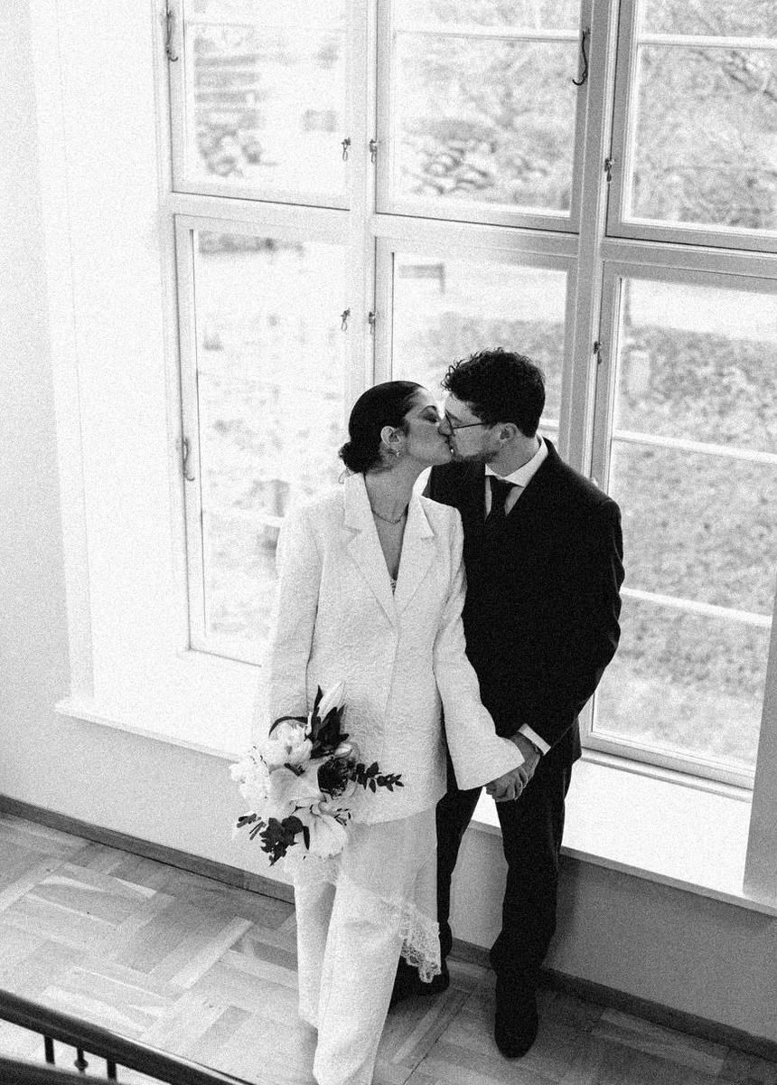 Layla y Dominik besándose junto a una ventana